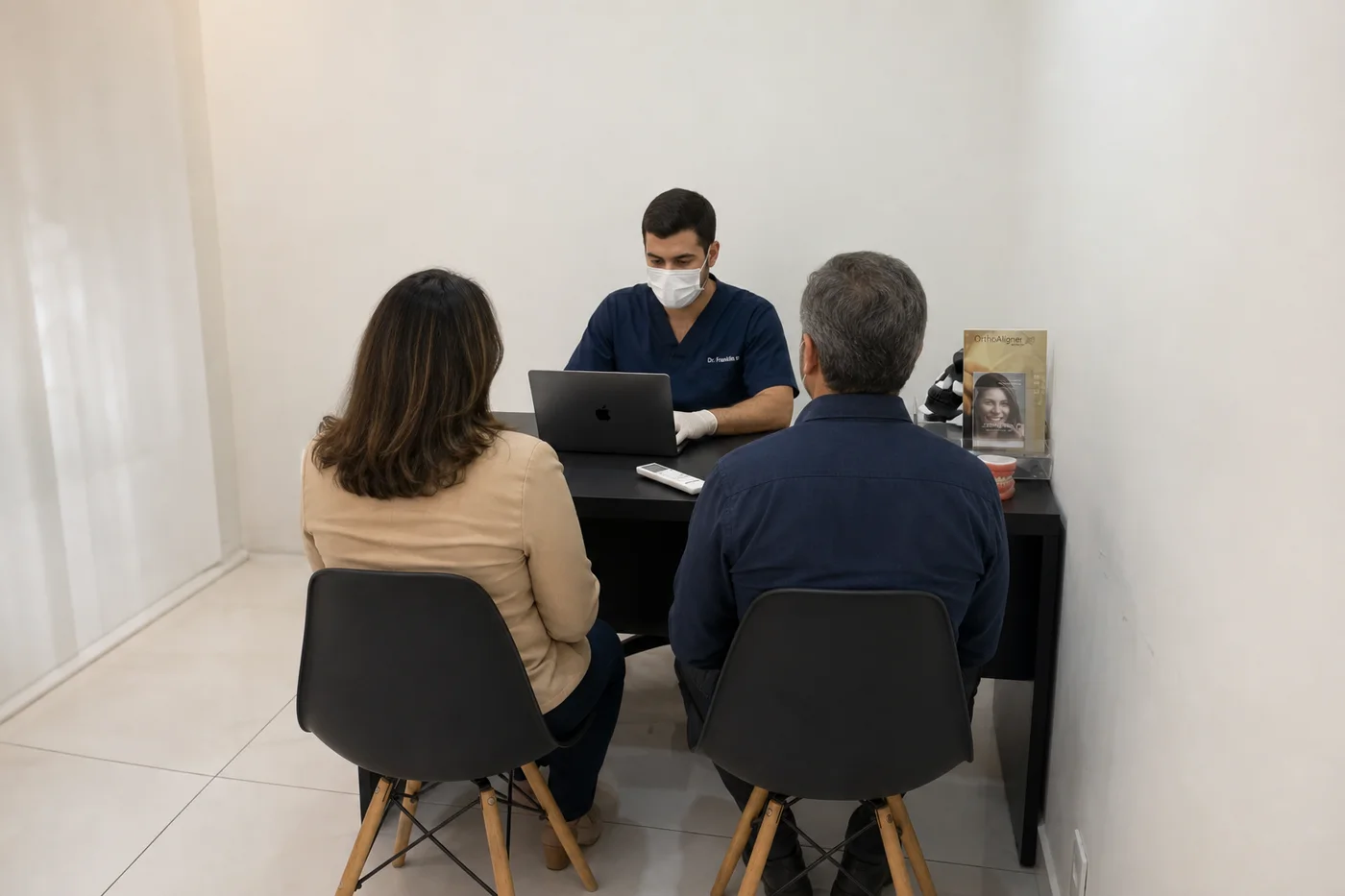 Dr. Franklin Araújo na mesa de consulta da Sobilis com paciente adulta — planejamento de ortodontia com alinhadores, Itapoã, Belo Horizonte